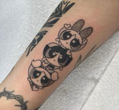 a person with a tattoo on their arm that has three small cartoon characters on it