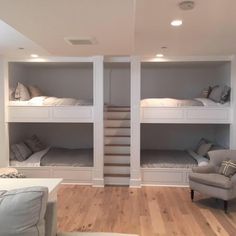 two bunk beds are in the middle of a room with white walls and wooden floors