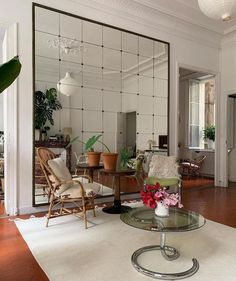 a living room filled with furniture and a large mirror on the wall above it's coffee table