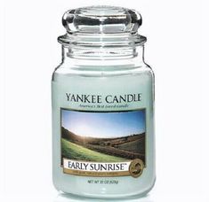 a yankee candle with an image of the countryside on it's front and side