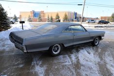 an old car is parked in the snow