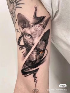 a woman's arm with a cat and bird tattoo on it