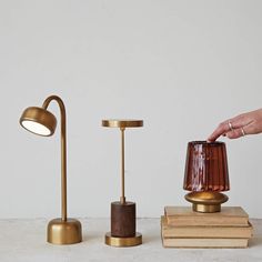 three different types of table lamps on top of books and a lamp with a brown shade