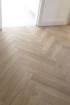 an empty room with wood flooring and white door