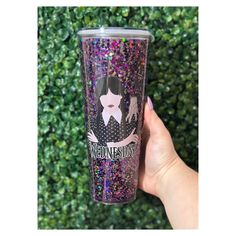 a hand holding a purple glittered tumbler cup