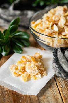 a close up of a bowl of food on a wooden table with napkins next to it