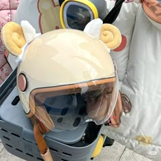 a helmet and goggles are sitting on the back of a scooter with ears