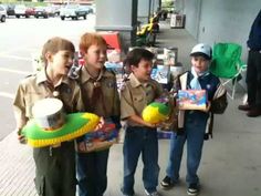 three young boys are holding toys on the sidewalk