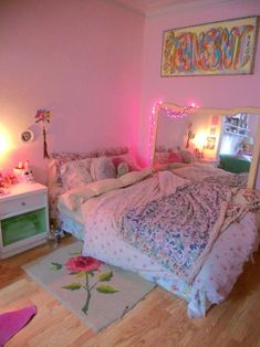 a bedroom with pink walls and wooden floors