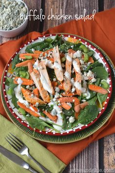 a salad with chicken, carrots and spinach in a bowl on a table