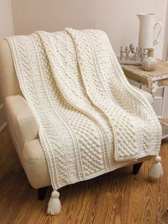 a white blanket sitting on top of a chair