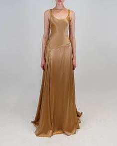 The Deepika gown features a scoop neckline and an elegant asymmetrical waistline that cascades into a flowy skirt with a smooth drape. Flowy Lace Dress, Charmeuse Gown, Godet Dress, Earth Tone Dress, Open Back Gown, Midi Gowns, Chiffon Gown, Bridesmaid Gown, Satin Slip Dress