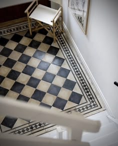 a black and white checkered floor in a room with a chair next to it