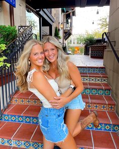 two beautiful young women hugging each other on the steps