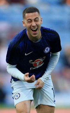 a soccer player with his mouth wide open and eyes wide open, laughing at the camera