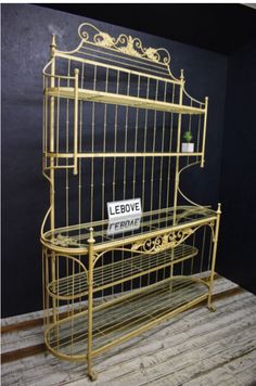 a gold metal shelf with a sign that says lebove on it and the bottom shelf is empty