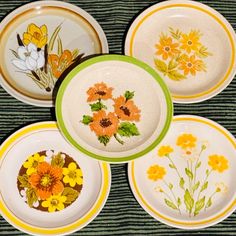 four plates with flowers painted on them