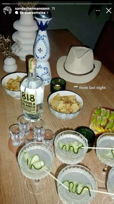 the table is set up with many dishes and glasses on it, including cucumbers