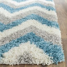 a blue and white rug on top of a wooden floor next to a wood floor