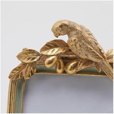 an ornate gold frame with a bird on it