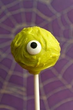 a green cake on a stick with googly eyes