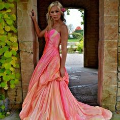 a woman in a pink and orange dress posing for the camera