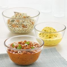 three bowls filled with different types of food on top of a table next to each other