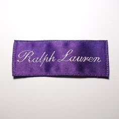 a purple cloth name tag with the word ruth lauren embroidered on it's side