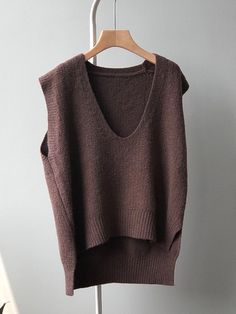 a brown sweater hanging on a clothes rack