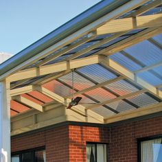 a bird is perched on the roof of a brick building with glass doors and windows