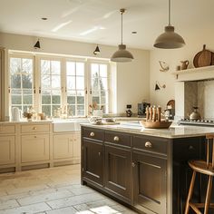 a large kitchen with an island in the middle and two stools at the end