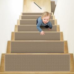 a young child climbing up the stairs in a house with carpet on the floor and wooden handrails