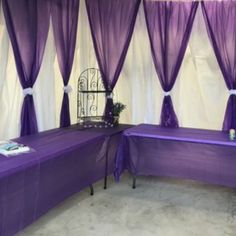 purple table cloths are set up in front of white drapes on the wall