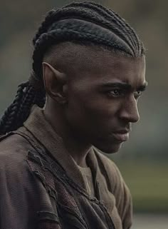 a man with braids on his head looking off to the side