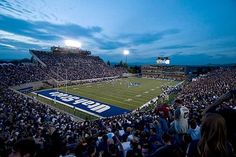 a stadium full of people watching a football game at night with the words utah state football on it