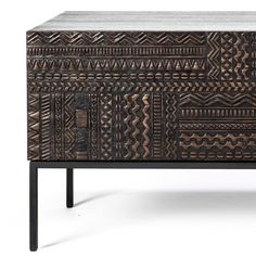 a wooden cabinet with an intricate design on the front and bottom, along with black legs