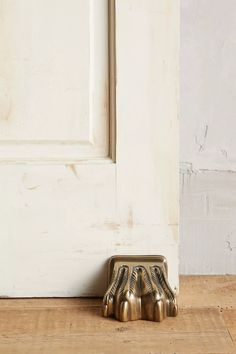 a pair of brass claw feet sitting in front of a white door