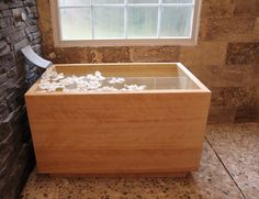 a large wooden box filled with lots of white flowers sitting in front of a window