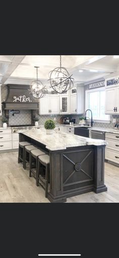 a large kitchen with white cabinets and an island