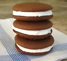 three cookies stacked on top of each other with white frosting in between the two