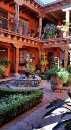 an outdoor courtyard with potted plants and water fountain