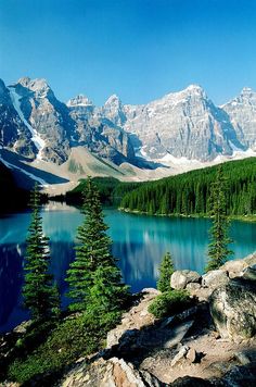 a lake surrounded by mountains and pine trees