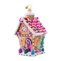 a christmas ornament shaped like a house with candy on the roof and windows