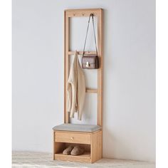 a wooden coat rack with two coats hanging on it's sides and a bench underneath