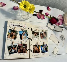 an open photo album with pictures and flowers on the table next to some other items