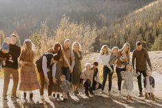 a group of people standing next to each other in front of a mountain range with trees