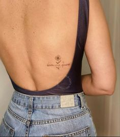 the back of a woman's body with a tattoo on her left shoulder and chest