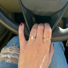 a woman's hand on the steering wheel of a car, while she is wearing a diamond ring