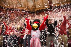 the mascot is surrounded by confetti as he stands in front of an audience