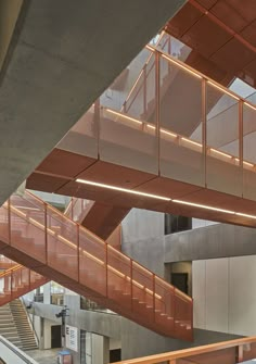 the inside of an office building with stairs and railings leading up to two floors